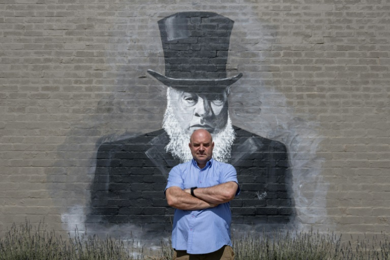 Le président adjoint de Kleinfontein, Dannie de Beer, le 19 septembre 2025 devant une fresque murale à Kleinfontein, en Afrique du Sud,  représentant Paul Kruger, ancien président de la République sud-africaine ( AFP / Wikus de Wet )