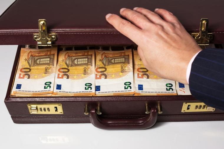 (Crédits photo : Adobe Stock - Homme ouvrant une mallette pleine de billets pour un paiement en espèces)