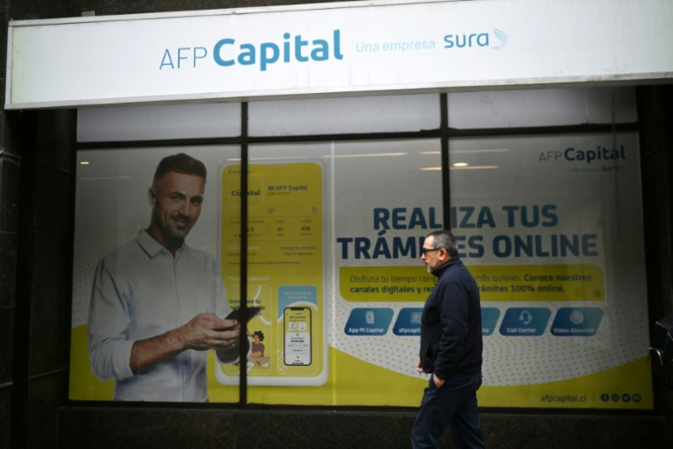 Un passant devant les bureaux d'une Administratrice de fonds de pension (AFP), à Santiago du Chili le 26 octobre 2026 ( AFP / Rodrigo ARANGUA )
