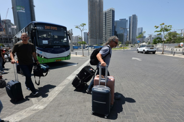 Des Israéliens descendent d'un bus après avoir été rapatriés en Israël par un vol spécial, le 18 juin 2025 à Tel Aviv ( AFP / GIL COHEN-MAGEN )