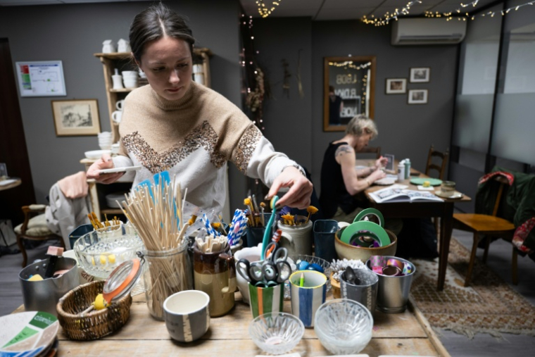 Une participante choisit des pinceaux lors d'un atelier dans un "café céramique" à Strasbour, le 21 avril 2026 dans le Bas-Rhin ( AFP / SEBASTIEN BOZON )