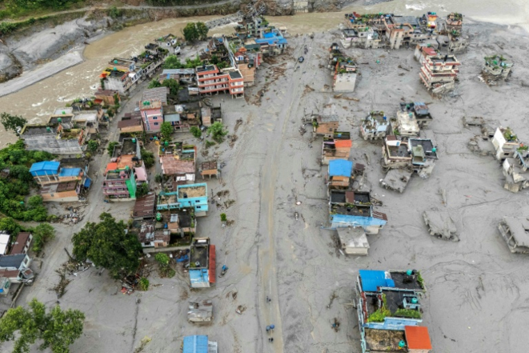 Vue aérienne de maisons recouvertes de boue et les débris après par la crue destructrice qui a fait plus de 600 morts à la frontière entre le Népal et la Chine, le 29 août 2026 à Devighat, dans le district népalais de Nuwakot ( AFP / Manan VATSYAYANA )