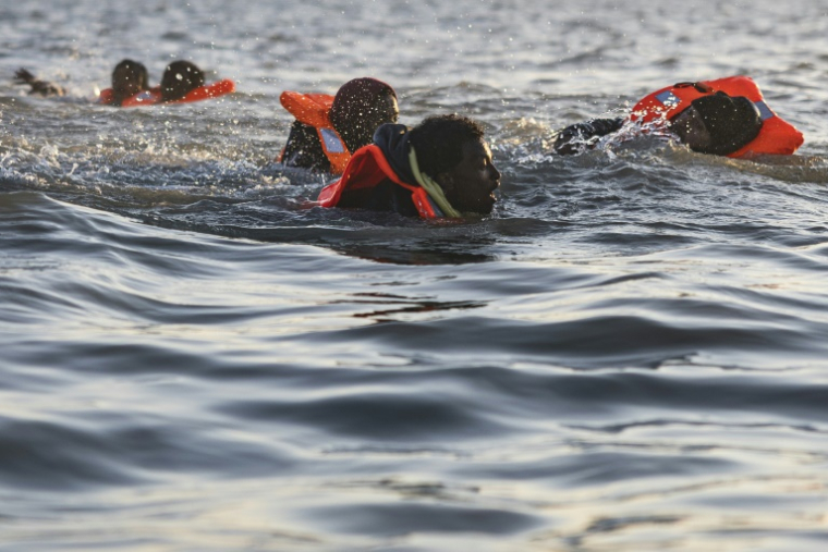 Des migrants nagent alors qu'ils tentent de monter à bord d'un bateau de passeurs pour traverser la Manche au large de la plage de Gravelines, le 16 juin 2025 dans le Nord ( AFP / Sameer Al-DOUMY )