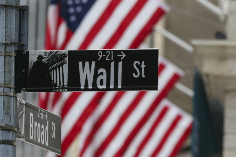 Un drapeau américain derrière un panneau Wall Street le 22 avril 2026 à New York ( AFP / ANGELA WEISS )