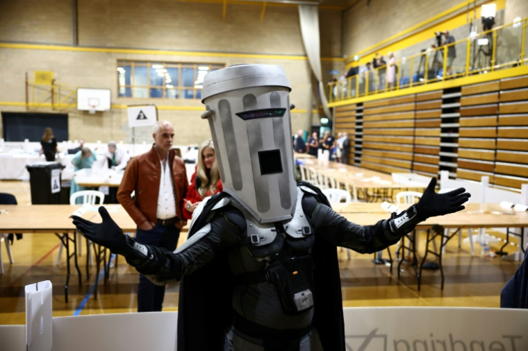 Le candidat satirique Count Binface arrive au centre de dépouillement pour connaître les résultats de l'élection législative partielle de Clacton, au Clacton Leisure Centre, dans l'est de l'Angleterre, le 14 août 2026 ( AFP / Henry NICHOLLS )
