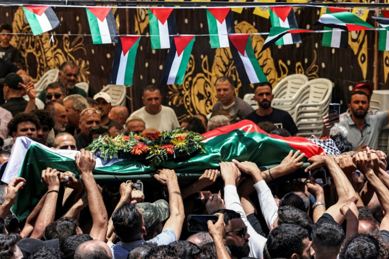 Le corps d'un jeune Palestinien, Mohammed al-Shalabi, porté par la foule lors de ses funérailles dans le village de Al-Mazra'ah ash Sharqïyah, en Cisjordanie occupée, le 13 juillet 2025 ( AFP / Zain JAAFAR )