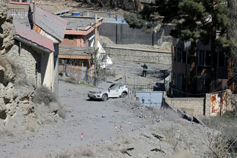 Une voiture endommagée après une frappe américaine sur le pont B1, le 3 avril 2026 à Karaj en Iran  ( AFP / ATTA KENARE )