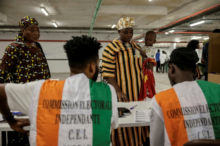 Des représentants de la commission électorale supervisent les opérations de vote pour la présidentielle ivoirienne, à Abidjan le 25 octobre 2025 ( AFP / EMMANUEL CROSET )