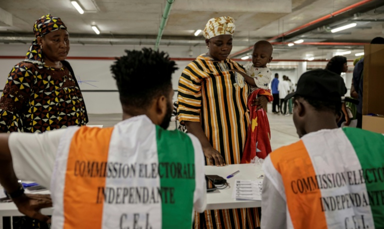 Des représentants de la commission électorale supervisent les opérations de vote pour la présidentielle ivoirienne, à Abidjan le 25 octobre 2025 ( AFP / EMMANUEL CROSET )