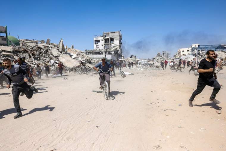 Des Palestiniens courent pour se mettre à l'abri lors d'une frappe de drone israélien à Jabalia, dans le nord de la bande de Gaza, le 23 mai 2025 ( AFP / Bashar TALEB )