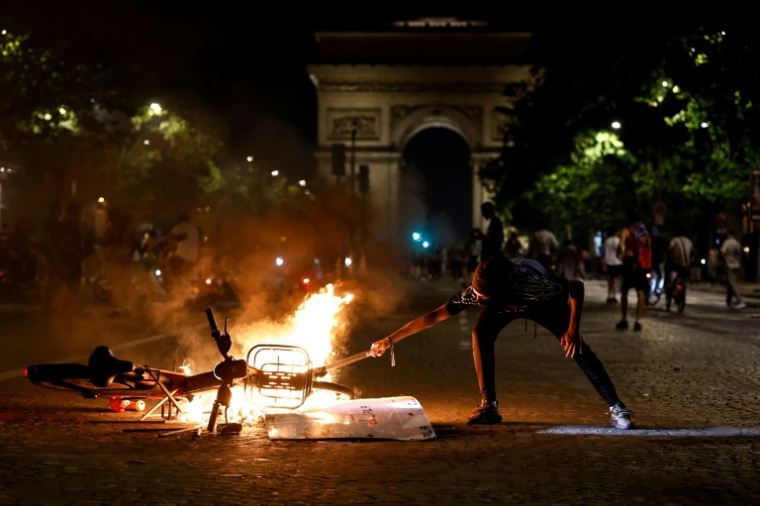 Une bicyclette en flammes sur les Champs-Elysées à Paris le 30 mai 2026 ( AFP / Kenzo TRIBOUILLARD )