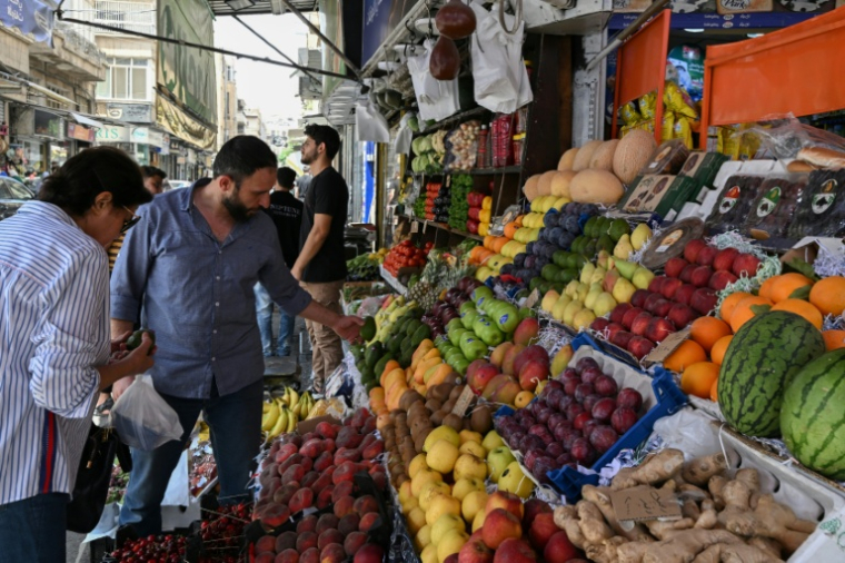 Un étal de fruits, dont des kiwis, des mangues et des ananas interdits à l'époque de Bachar al-Assad, dans une rue de Damas, le 26 mai 2025 en Syrie ( AFP / LOUAI BESHARA )