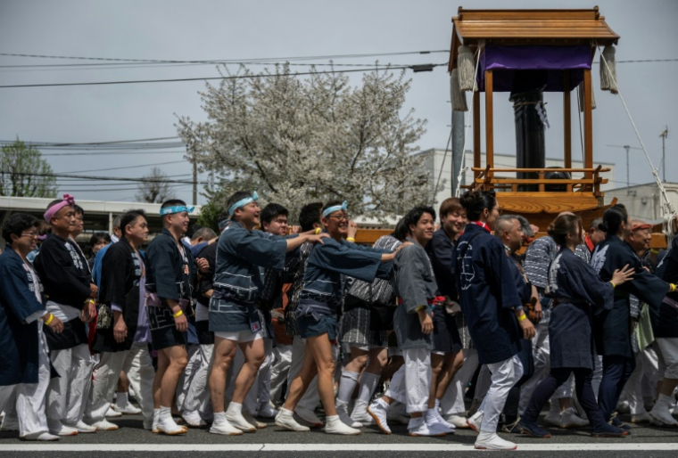 Des festivaliers portent un phallus factice géant à Kawasaki près de Tokyo pendant le festival Kanamara le 5 avril 2026 ( AFP / Andrew CABALLERO-REYNOLDS )