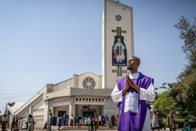 Un prêtre catholiwque prie devant la cathédrale Saint Michael de Minna, au Nigeria le 30 novembre 2025 ( AFP / Light Oriye Tamunotonye )