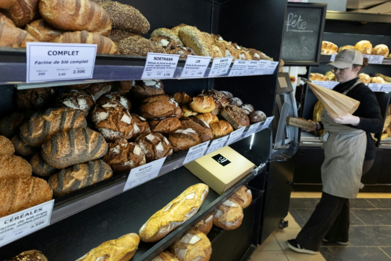 Une employée sert du pain à des clients dans une boulangerie à Quimper, le 1er mai 2026 dans le Finistère ( AFP / Fred TANNEAU )