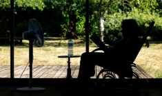 Une personne âgée assise face à un ventilateur à Pont-Audemer, dans l'Euroe, le 12 juillet 2026 lors d'une vague de chaleur en France ( AFP / JOEL SAGET )