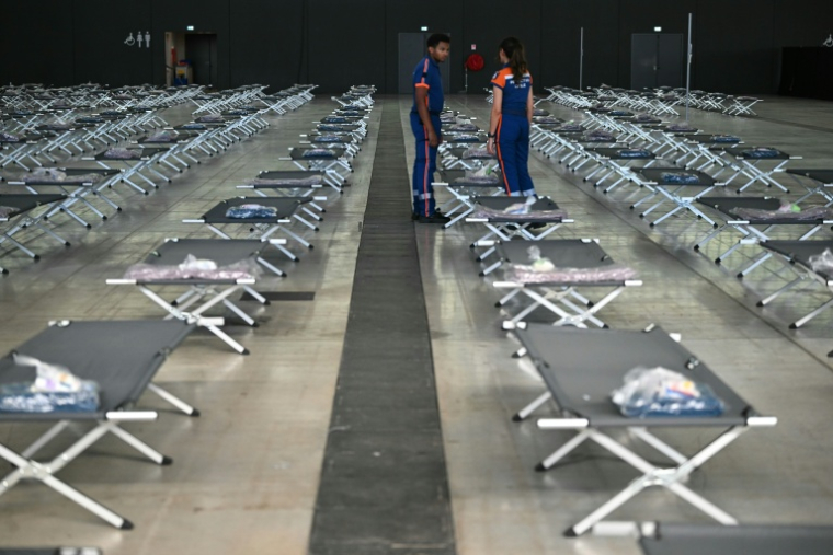 Des membres de la protection civile préparent des lits pour accueillir les personnes déplacées par le mégafeu en Gironde, le 28 juillet 2026 à Aussonne, près de Toulouse  ( AFP / Lionel BONAVENTURE )