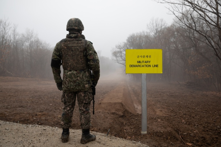 Un soldat sud-coréen devant un panneau marquant la ligne de démarcation militaire entre la Corée du Sud et la Corée du Nord, le 3 décembre 2018 près de Cheorwon, dans le nord de la Corée du Sud ( AFP / Yelim LEE )