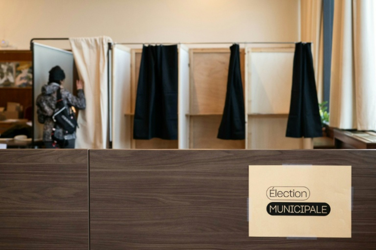 Un électeur entre dans l'isoloir pour voter au premier tour des municipales, le 15 mars 2026 à Lyon ( AFP / ARNAUD FINISTRE )