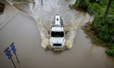 Un camion avance sur une route inondée, dans la région de Naguabo, à Porto Rico, le 16 août 2025 ( AFP / Ricardo ARDUENGO )