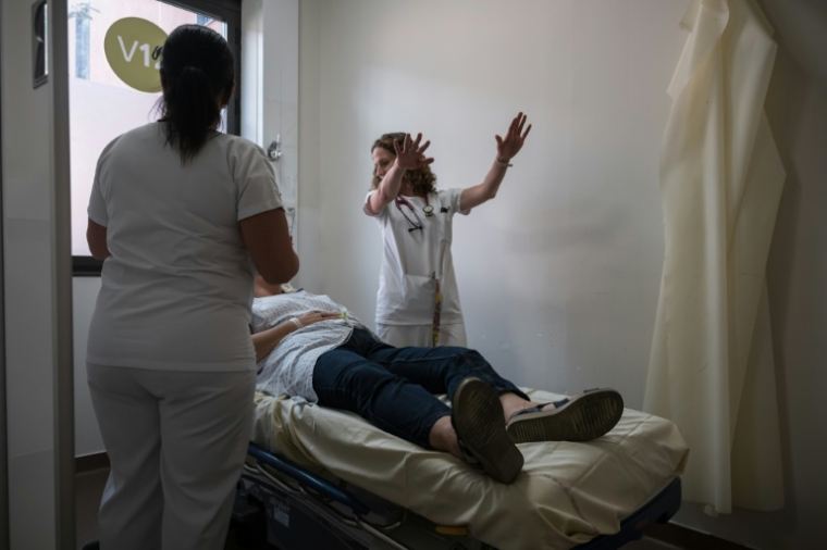 Une patiente souffrant de la canicule est examinée à l'hôpital Purpan de Toulouse le 23 juin 2026 ( AFP / Ed JONES )