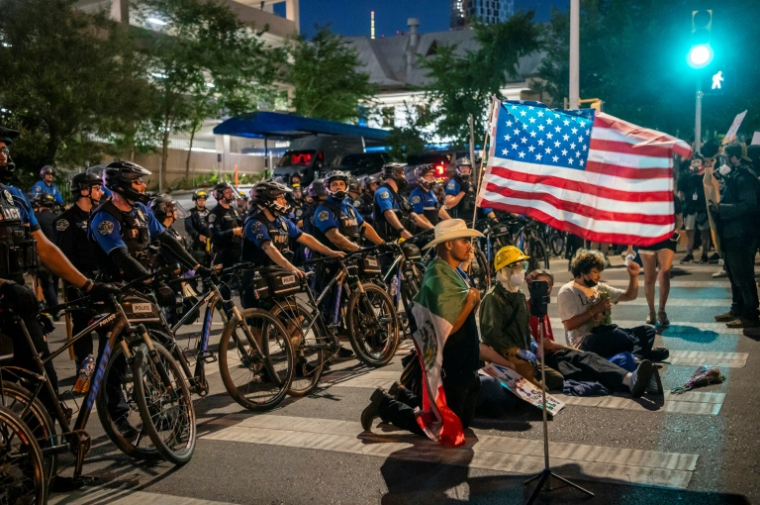 Des manifestants opposés aux politiques de Donald Trump face à des policiers, lors d'un rassemblement "No Kings" à Austin au Texas, le 14 juin 2025 ( AFP / SERGIO FLORES )