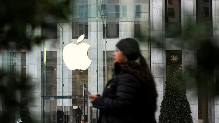 Photo d'une femme qui marche près de l’Apple Store à New York