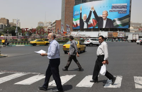 Des passants devant une photo du chef du Hamas assassiné, Ismail Haniyeh, et du président iranien, Masoud Pezeshkian, à Téhéran, en Iran