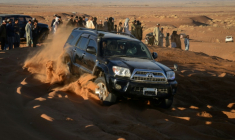 Des passionnés d'automobile au volant d'un 4X4 dans les dunes de la province de Kandahar, le 5 décembre 2025 en Afghanistan ( AFP / Sanaullah SEIAM )