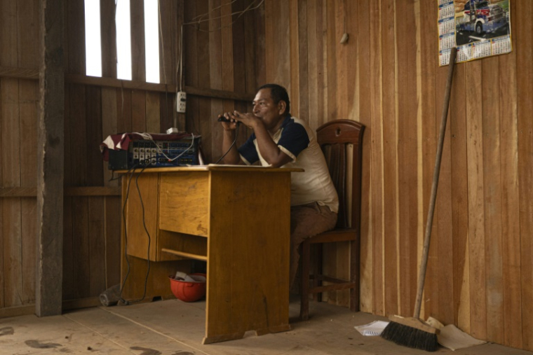 Abner Ancon, 54 ans, membre de la garde indigène shipibo-konibo, utilise une radio à Caimito, dans le département d'Ucayali, au Pérou, le 20 mars 2025 ( AFP / Ernesto BENAVIDES )
