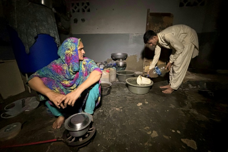 Maryam Suleman et son fils Ahmed Raza, tous deux non inscrits à l'état-civil, dans leur maison à Karachi, le 19 juin 2025 au Pakistan ( AFP / Rizwan TABASSUM )