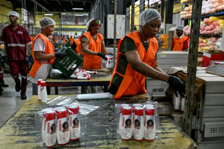 Des employées emballent des produits cosmétiques dans l'usine Kaera, située dans la zone industrielle de Yopougon, en périphérie d'Abidjan, le 7 juillet 2026 en Côte d'Ivoire ( AFP / Issouf SANOGO )