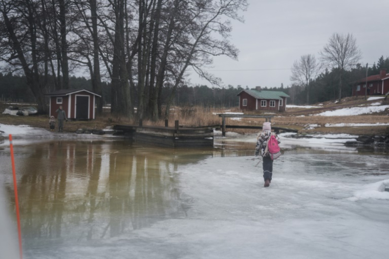 Une écolière finlandaise, Julia Jalkanen, marche en direction de sa mère après être rentrée de l'école en aéroglisseur, à Pargas, le 3 mars 2026 ( AFP / Alessandro RAMPAZZO )