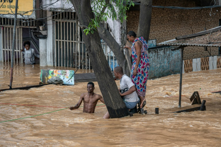 Des habitants dans un quartier inondé à Kinshasa, après des pluies diluviennes, le 6 avril 2025 en RDC ( AFP / Hardy BOPE )