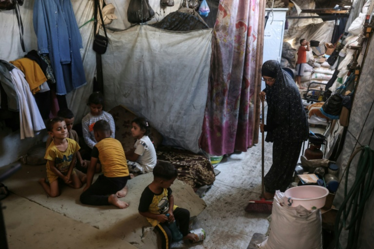 Nihaya Al-Masri (D), une Palestinienne déplacée qui vit avec ses huit enfants sous une tente à Khan Younès, dans le sud du territoire palestinien, le 6 octobre 2026  ( AFP / Bashar Taleb )
