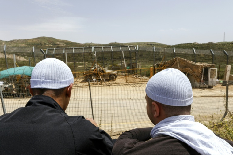 Des druzes syriens observent un véhicule militaire israélien dans le village de Majdal Shams, sur le plateau du Golan annexé par Israël, le 30 avril 2025 ( AFP / Jalaa MAREY )
