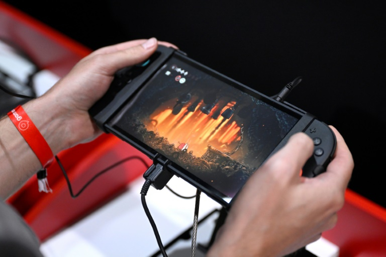 Des particpants jouent au jeu vidéo Hollow Knight: Silksong de Team Cherry sur le stand Nintendo lors du salon des jeux vidéo Gamescom, le 21 août 2025 à Cologne, en Allemagne ( AFP / Ina FASSBENDER )