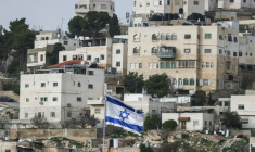 Un drapeau israélien flottant du dessus d'une colonie israélienne, devant des habitations palestiniennes d'Hébron, en Cisjordanie, le 9 février 2026 ( AFP / HAZEM BADER )
