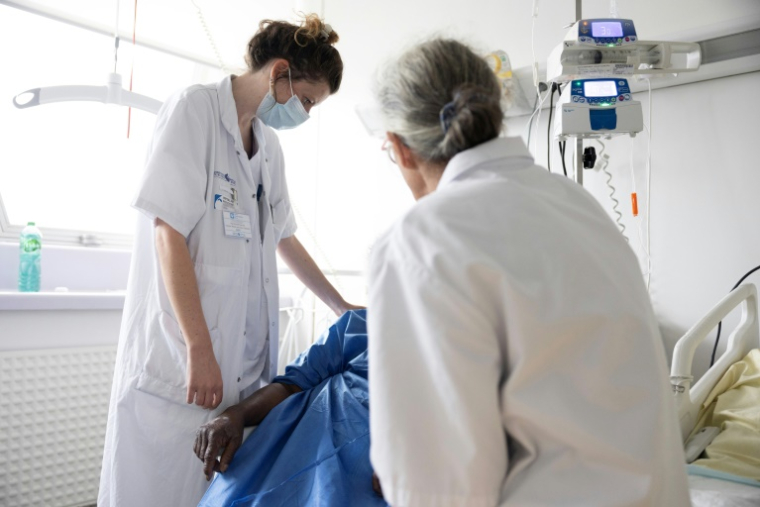 Une médecin et une psychomotricienne du service mobile de soins palliatifs au chevet d'une patiente de l'hôpital Antoine-Béclère de l'AP-HP, à Clamart le 27 mai 2025 ( AFP / Thomas SAMSON )