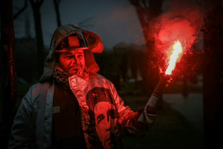 Un employé d'ArcelorMittal, portant son équipement de protection orné d'autocollants de la CGT et d'un portrait du révolutionnaire argentin Ernesto Che Guevara, participe à une action organisée par la CGT sur l'Esplanade des Invalides, à Paris, le 27 novembre 2025, afin de soutenir le projet de loi LFI de nationalisation d'ArcelorMittal France ( AFP / Alain JOCARD )