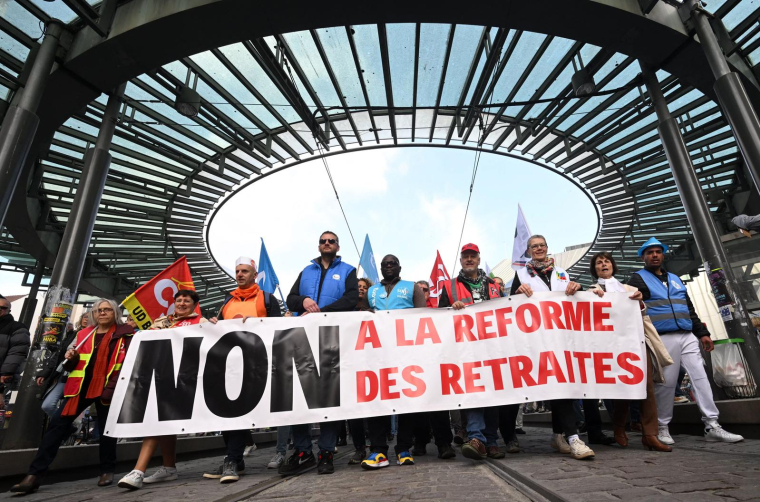 Des manifestants défilent derrière une banderole indiquant "Non à la réforme des retraites" lors de la manifestation du 1er Mai à la place de l’Homme-de-Fer à Strasbourg, le 1er mai 2023.  ( AFP / FREDERICK FLORIN )