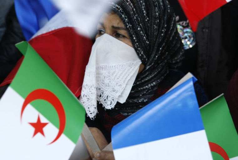 Une algérienne tenant des drapeaux algérien et français