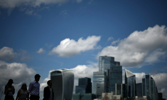 Des passants le long de la rive sud de la Tamise d'où l'on aperçoit le quartier des affaires et financier du centre de Londres, le 14 août 2025 ( AFP / HENRY NICHOLLS )