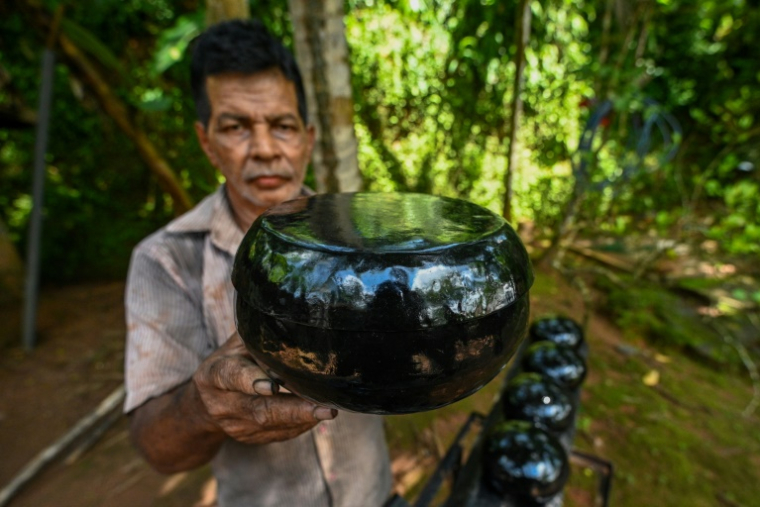 Le forgeron Thenuwara Badalge Sarath fabrique des bols utilisés par les moines bouddhistes pour solliciter l'aumône dans un village de Panvila, au Sri Lanka, le 2 juin 2025 ( AFP / Ishara S. KODIKARA )