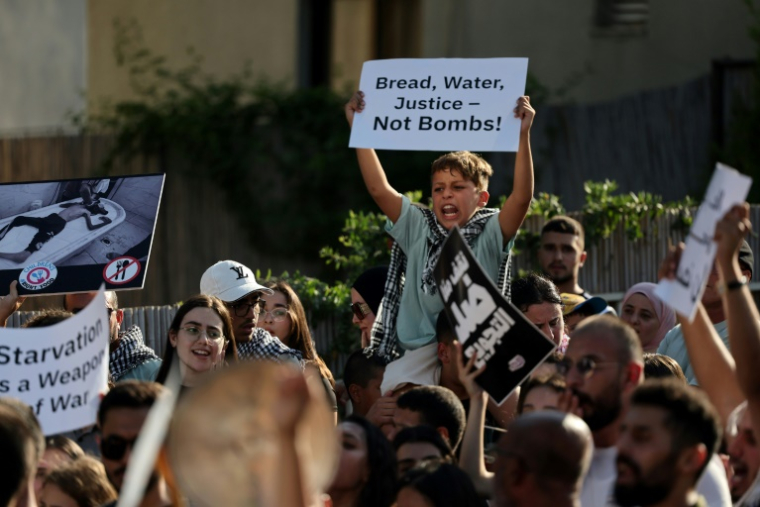 Un jeune garçon brandit une pancarte lors d'une manifestation dans la ville arabe israélienne de Sakhnin pour dénoncer les graves pénuries de nourriture dans la bande de Gaza et l'offensive israélienne, le 25 juillet 2025 ( AFP / Ahmad GHARABLI )