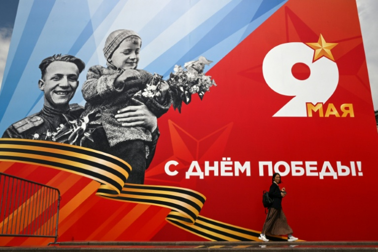 Une femme passe devant une affiche célébrant le "jour de la Victoire" pour les commémorations du 81 anniversaire de la capitulation allemande en 1945, le 6 mai 2026 à Moscou ( AFP / Igor IVANKO )
