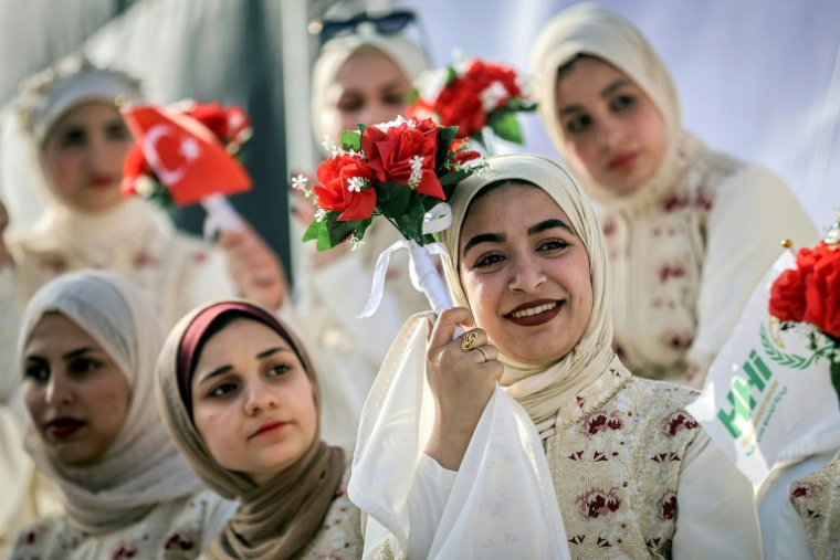 Des jeunes femmes s'apprêtent à participer à un cérémonie de mariage collectif dans la ville de Gaza le 11 mai 2026. ( AFP / Omar AL-QATTAA )