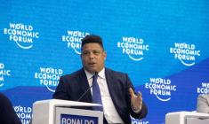 La légende du football brésilien Ronaldo fait un geste pendant une discussion de panel à Davos