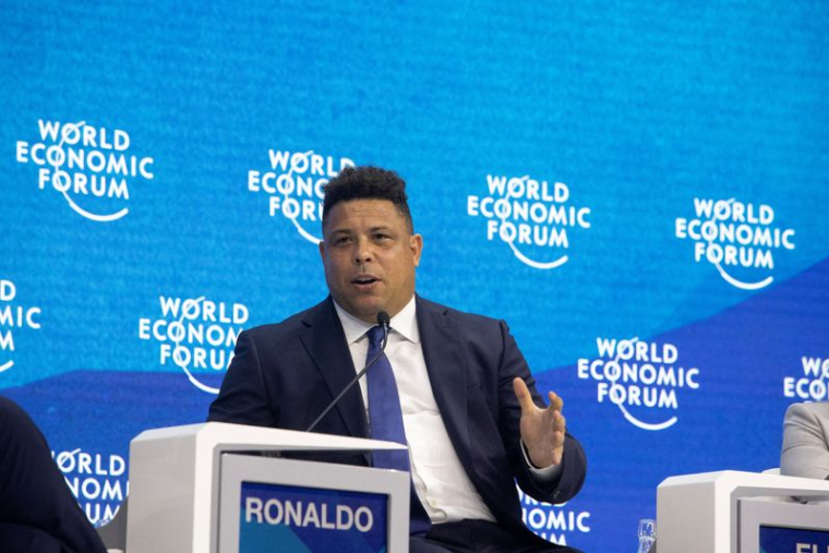 La légende du football brésilien Ronaldo fait un geste pendant une discussion de panel à Davos