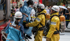 Les secours aident une femme qui était dans un centre commercial quand un homme y a pulvérisé une substance, à Tokyo, le 25 mai 2026 ( AFP / Andrew CABALLERO-REYNOLDS )
